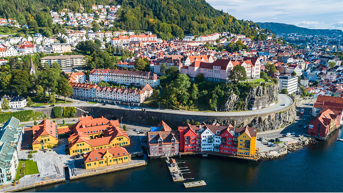 An aerial view of a vibrant coastal city built into a lush green mountainside