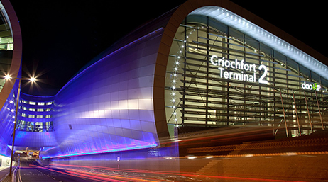 An exterior image of Dublin Airport lit in purple and white under a black night sky