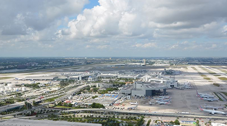 An aerial image of Miami International Airport under a cloudy blue sky