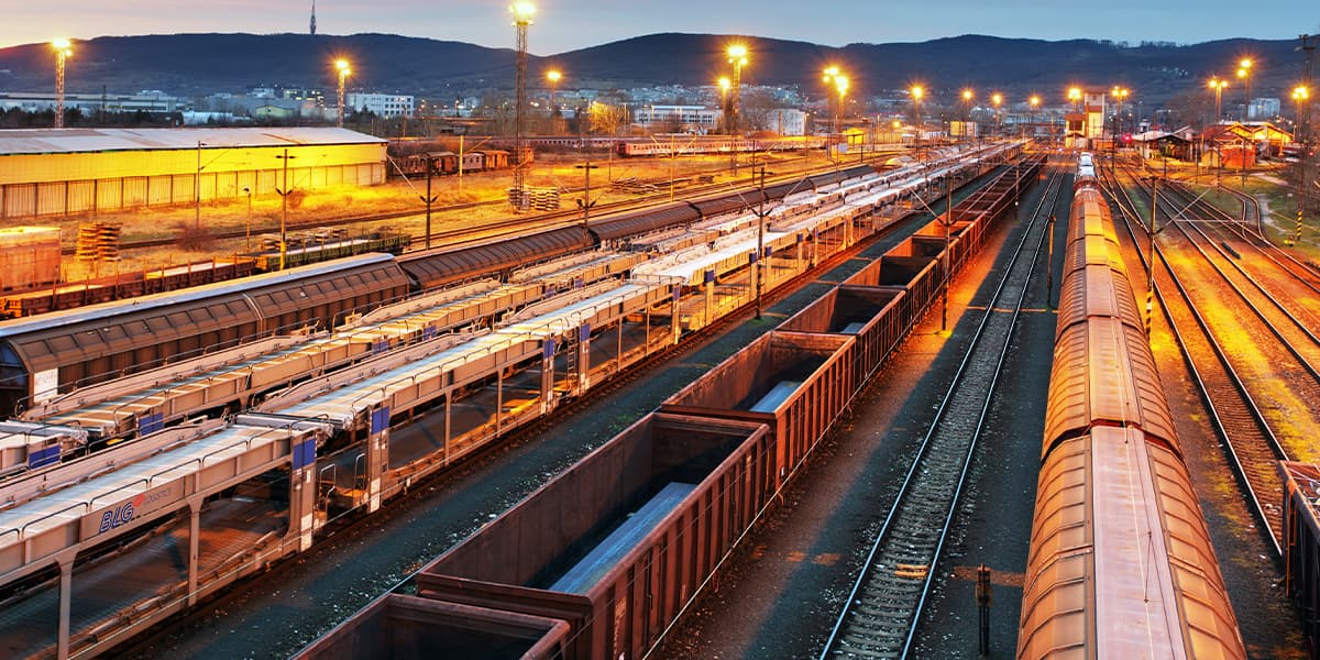 Rail yard at dusk with a mountain range in the background