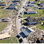 An aerial view of a residential neighborhood with houses damaged from a tornado