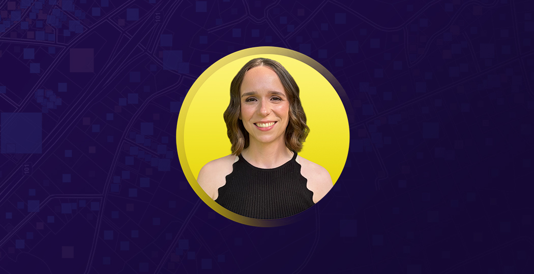 Portrait of Shivon Van Allen smiling in a black camisole with a flat yellow background