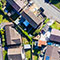 An aerial photo of a sunny residential neighborhood with bright green lawns and medians