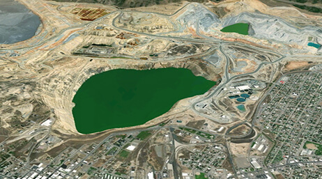 Aerial image of a landlocked green lake surrounded by a large city
