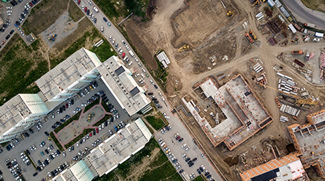 An aerial image of a busy road running through an industrial complex under construction