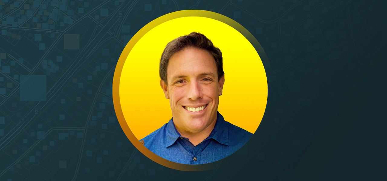 Portrait of Steven Hochart smiling in a blue collared shirt