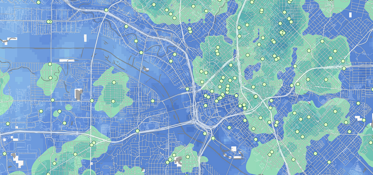 A blue map bisected by a river with regions shaded in green and small, green dots dispersed throughout