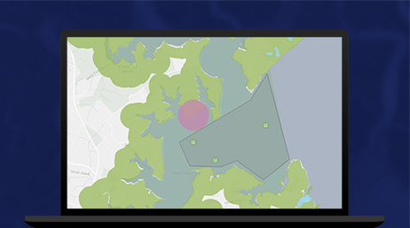 A map with a purple dot in the middle of a green area displayed on a laptop computer