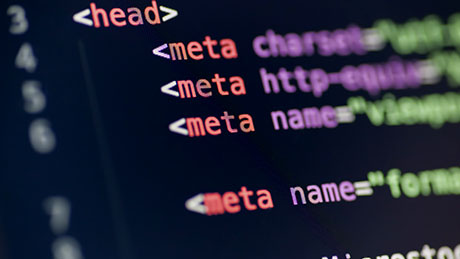 A closeup photo of computer code in multicolored script on a black screen