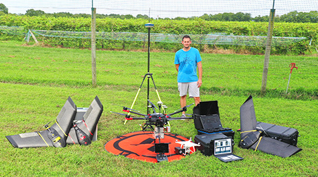 A person outside in a field surrounded by large drone equipment