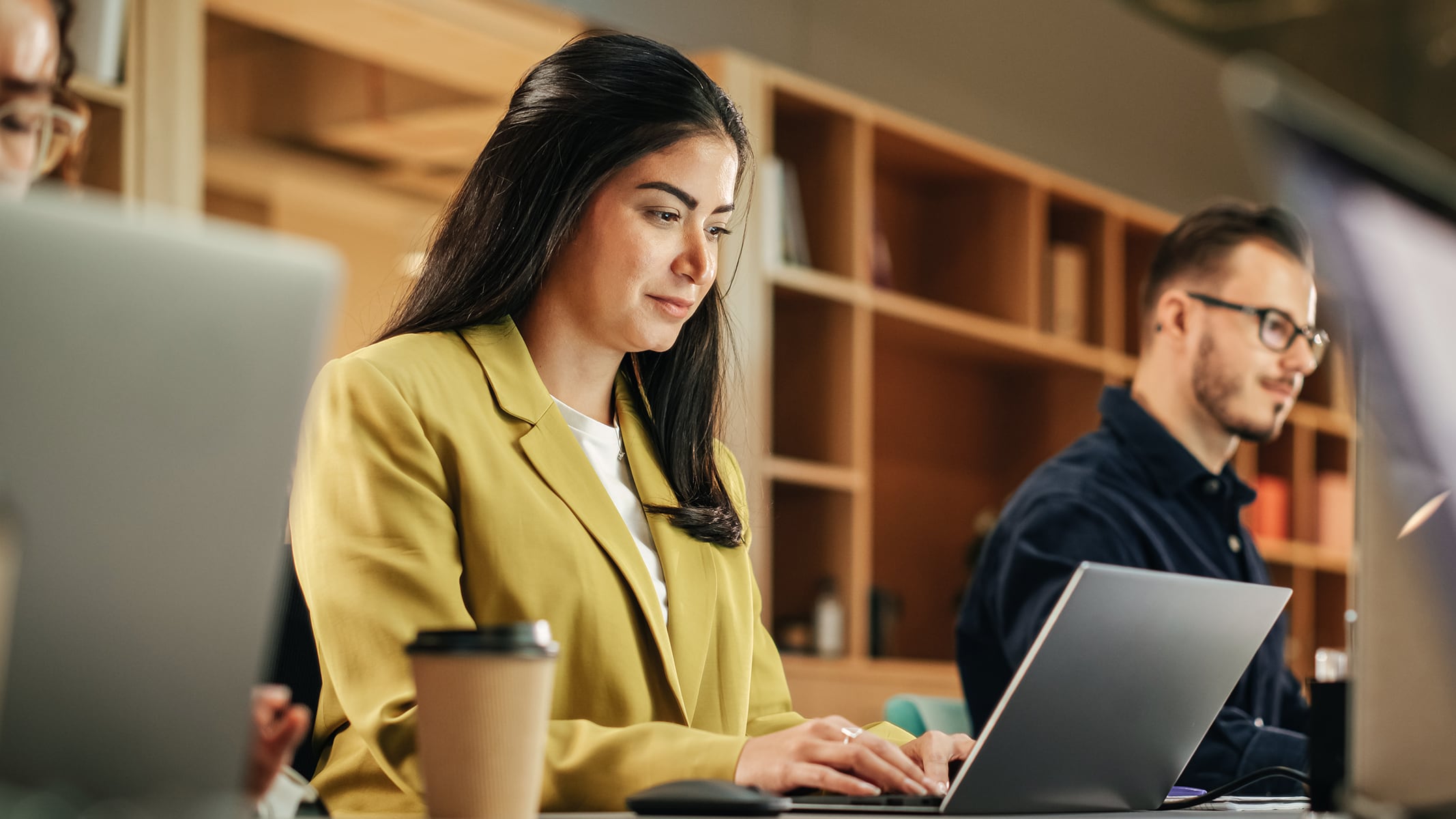 People sitting next to each other at a table using laptops