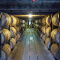 A bourbon rickhouse with rows of large wooden barrels stored in racks to the ceiling