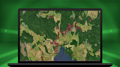A graphic of a laptop monitor displaying an aerial map of a dark and light green forest with small areas highlighted in purple