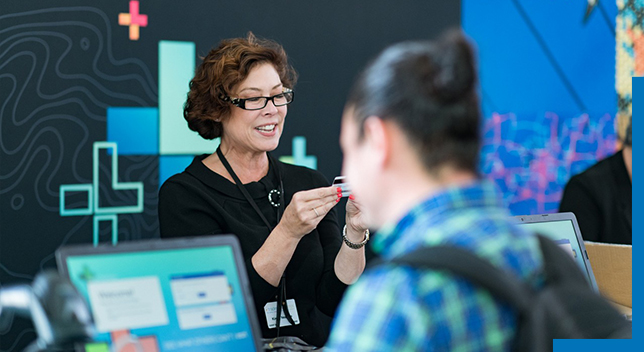 Frau, die Teilnehmern bei der Esri User Conference behilflich ist