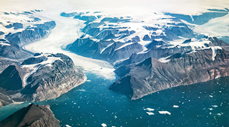 An aerial view of the snowy coast of Greenland