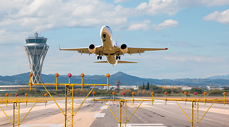 An airplane lifting off from a runway under a cloudswept blue sky