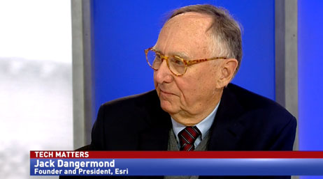 A screencap from the featured video with Jack Dangermond in a dark blazer, looking at an unseen speaker on the left, against a blue and white background