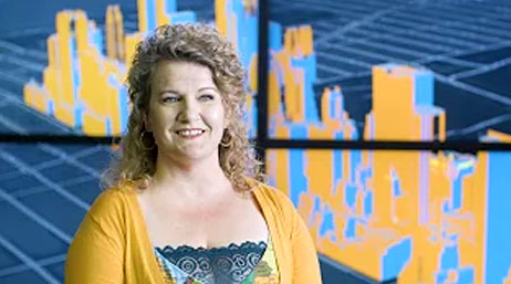 A screencap from the featured video with a smiling person in a yellow sweater against an abstract blue and yellow background