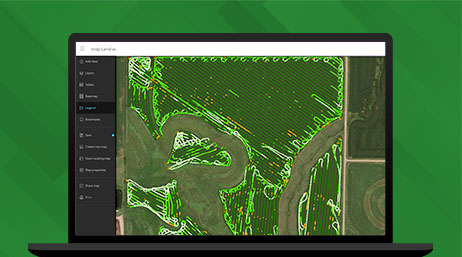 Graphic of a laptop monitor displaying a map of green farmland alongside a map legend on a green background