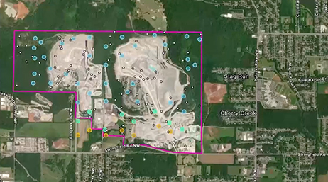 Aerial map view showing a large, pink-outlined area containing two light-colored mining sites