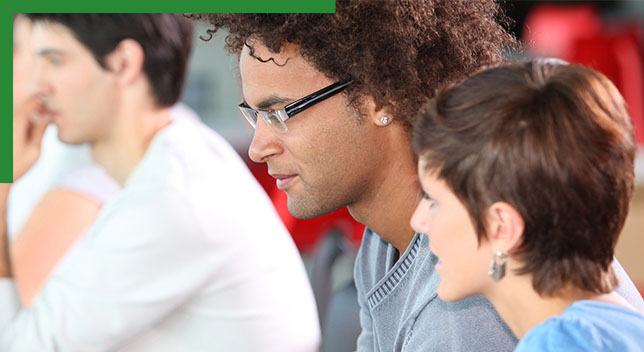 Personnes assises regardant attentivement des documents de formation