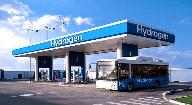 Graphic of a blue and white hydrogen station with a bus parked within under a blue sky scattered with puffy clouds