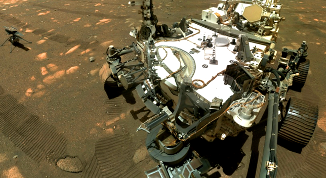 A white robotic rover on a brown planet surface