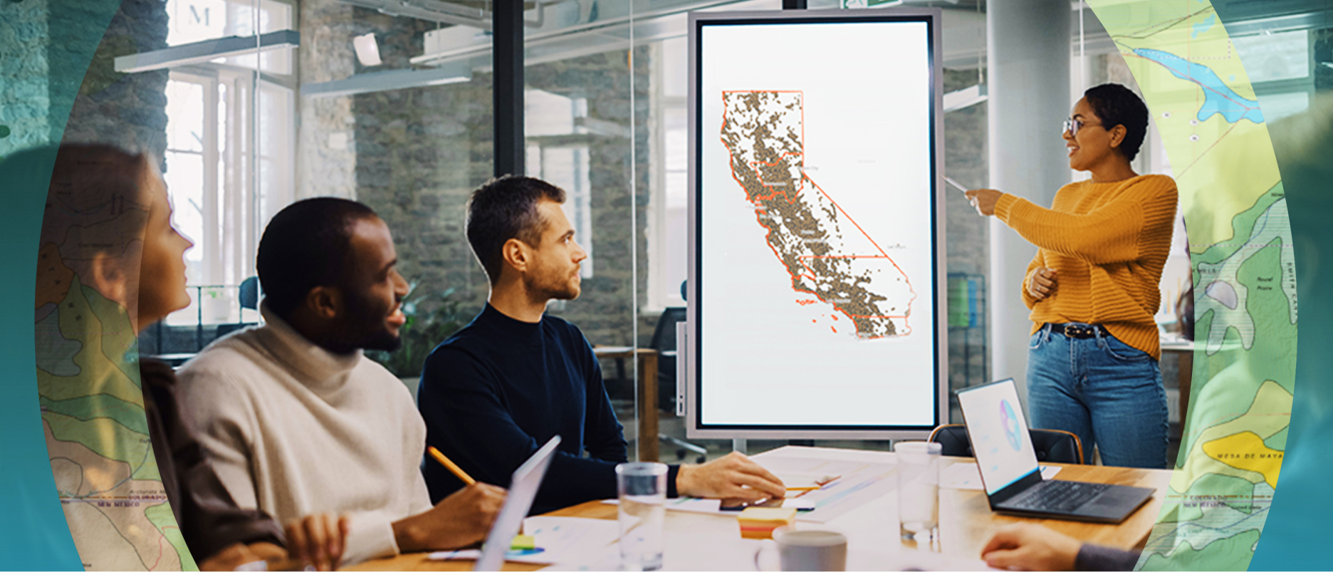 People at a conference table looking at a large digital map