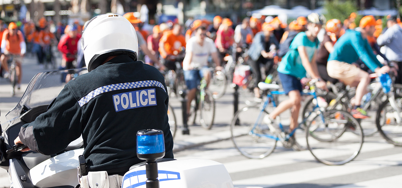 Police officer on a motorcycle near a group of people on bicycles