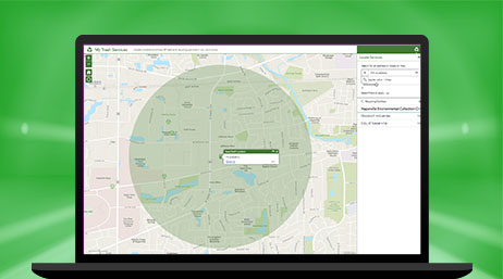 A laptop displaying a map with a large green circle in the center identifying an area