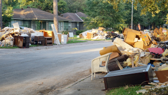 A residential street surrounded by large piles of debris