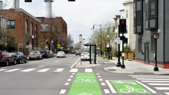 An intersection with clearly marked bike lanes and crosswalks in a densely developed urban area