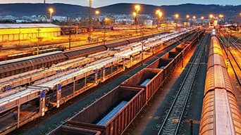 Rail yard at dusk with a mountain range in the background