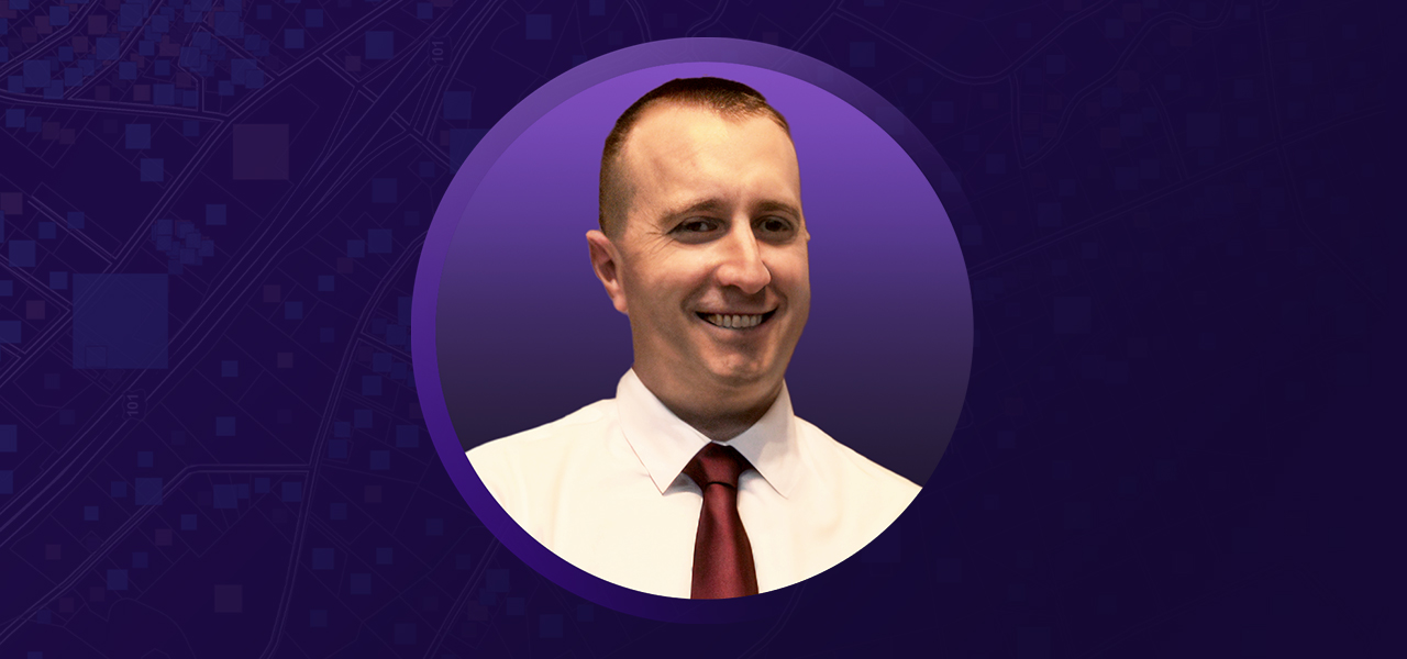 Kris Boccio smiling and wearing business attire overlaid on a purple graphic background