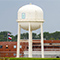  A red brick water treatment facility with a large white water tower in the foreground