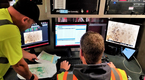 An IT worker and a utility worker using desktop GIS software
