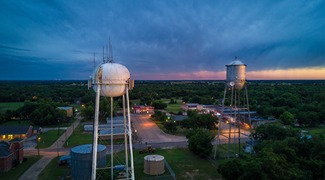 Two water towers above a town at dusk