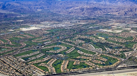 An aerial photo of a large suburb with mountains in the distance