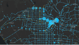 A city street map in bright blue on a dark gray background scattered with blue concentration points