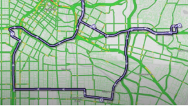 A beige street map with routes shown in green and purple