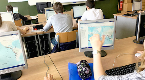 A classroom full of students sitting at rows of computer stations