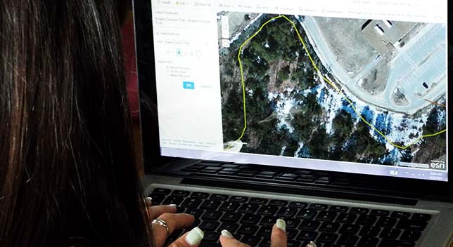 A photo taken over the shoulder of a student using a classroom computer station to access an aerial photo with a legend of analysis options