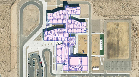 An aerial photo of a school overlaid with a schematic of the interior layout of classrooms and public spaces