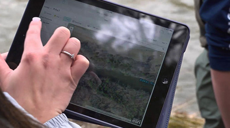 A closeup photo of a hand using a tablet to access a digital map
