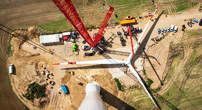 A view from the top of a wind turbine down to the ground of the construction site below
