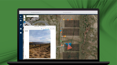 A laptop computer showing an aerial view a solar farm and a zoomed in image of on solar panel plot