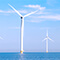 Wind turbines built on concrete stands sticking out of the ocean