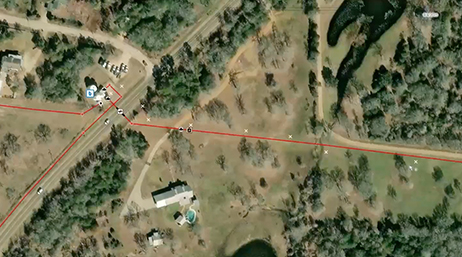Aerial imagery overlaid with a red line symbolizing the path of a pipeline overlaid with a play button