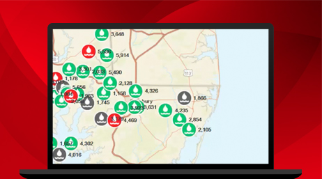 A laptop displaying a map with red, green, and gray icons