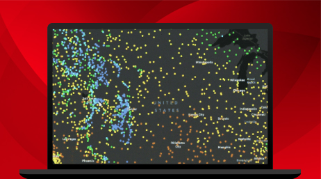 A laptop displaying a dark map with red, yellow, green, and blue location dots